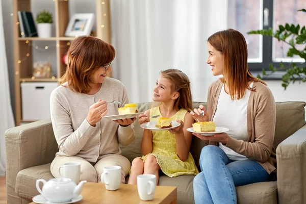Мать, дочь и бабушка едят торт — стоковое фото