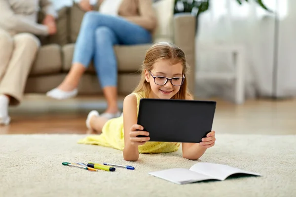 Schülerin mit Tablet-PC zu Hause auf dem Boden liegend — Stockfoto