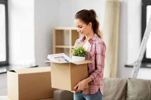 Mujer feliz con cosas mudándose a un nuevo hogar —  Fotos de Stock