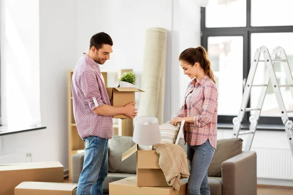 Happy couple with stuff moving to new home — Stock Photo, Image