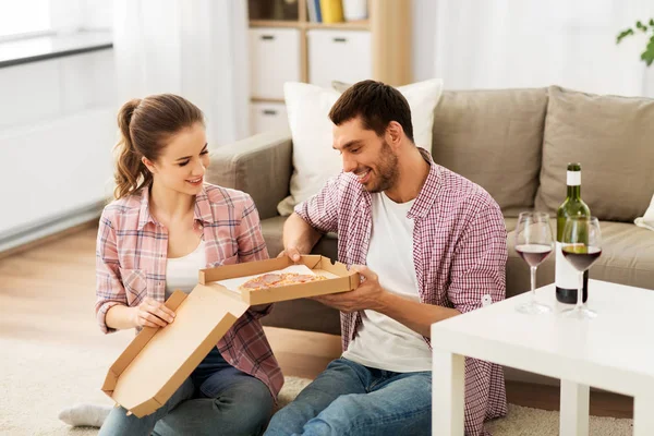 Coppia con vino mangiare pizza da asporto a casa — Foto Stock