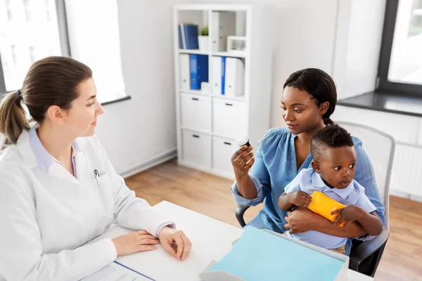 Médico y mujer con bebé y medicina en la clínica — Foto de Stock