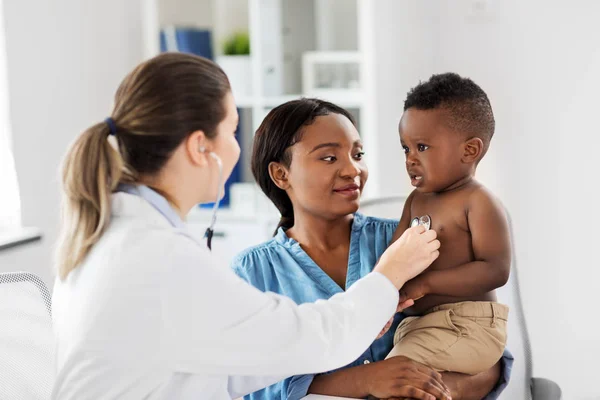 Arzt mit Stethoskop hört Baby in Klinik — Stockfoto