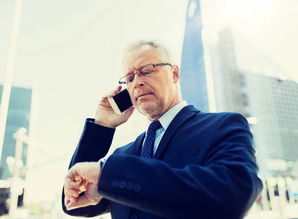 Senior zakenman belt op smartphone in de stad — Stockfoto