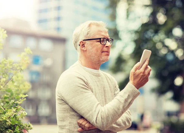 Starší muž SMS zpráva na smartphone v městě — Stock fotografie