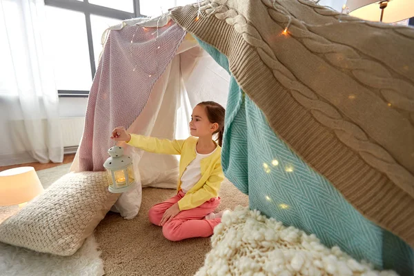Bambina con lanterna in tenda per bambini a casa — Foto Stock