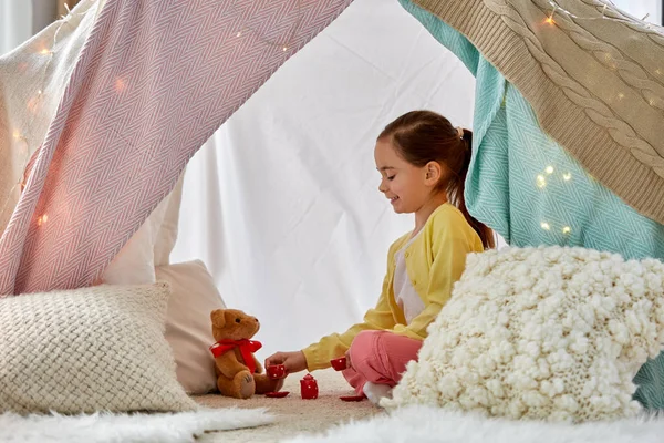 Menina jogando chá festa com pelúcia na tenda crianças — Fotografia de Stock