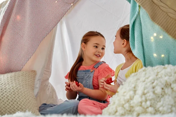 Küçük kız evdeki çocuk çadırında çay partisi veriyor. — Stok fotoğraf