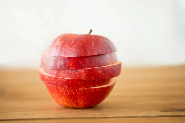 Viipaloitu punainen omena puinen pöytä — kuvapankkivalokuva