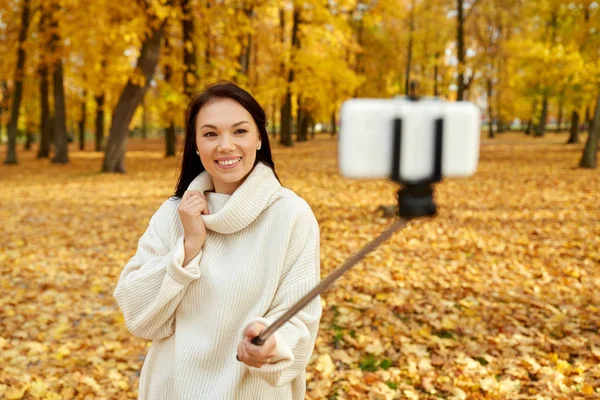 Woman taking selfie by smartphone at autumn park — Stock Photo, Image