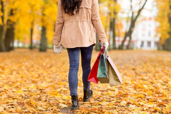 Vrouw met boodschappentassen wandelen langs herfst park — Stockfoto