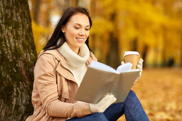 Mulher ler livro com café no parque de outono — Fotografia de Stock