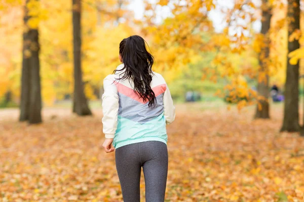Jonge vrouw loopt in de herfst park — Stockfoto