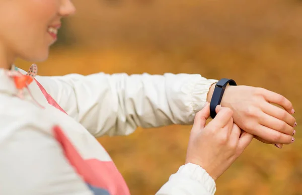 Woman with fitness tracker outdoors in autumn — Stock Photo, Image