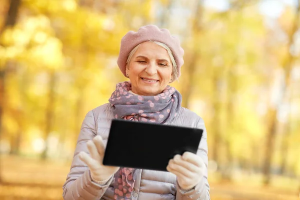 Senior vrouw met tablet pc in zomerpark — Stockfoto