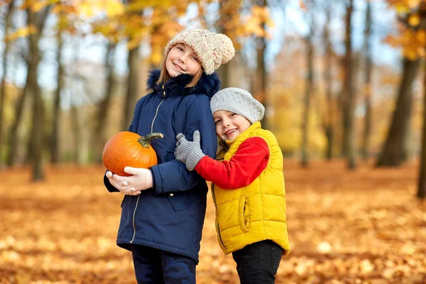 Glückliche Kinder beim Kürbiskuscheln im Herbstpark — Stockfoto