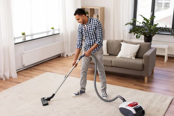 Pria indian dengan vacuum cleaner di rumah — Stok Foto