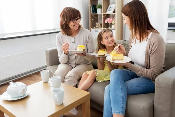 Anne, kız ve büyükanne pasta yiyor. — Stok fotoğraf