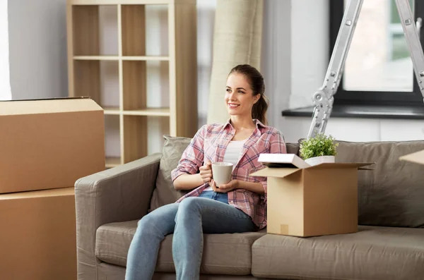 Vrouw verhuizen naar nieuw huis en het drinken van koffie — Stockfoto
