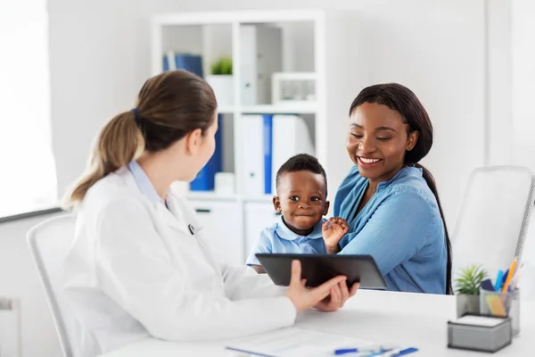 Mère avec bébé et médecin avec comprimé à la clinique — Photo