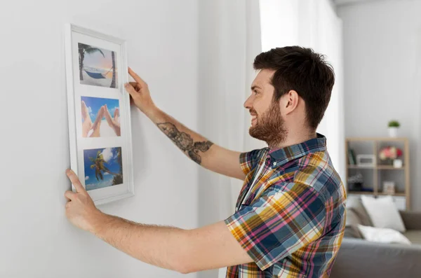 Mann hängt Bild in Rahmen an Wand zu Hause — Stockfoto