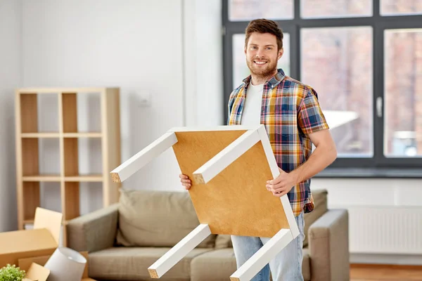 Happy man with table moving to new home — Stock Photo, Image