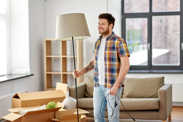 Hombre feliz con lámpara de pie que se mueve a un nuevo hogar —  Fotos de Stock