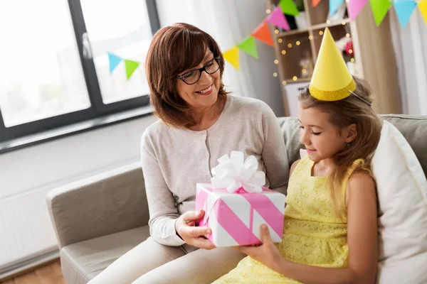 Babička dává vnučce dárek k narozeninám — Stock fotografie