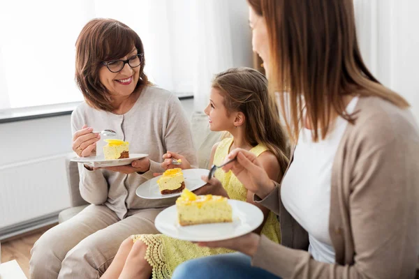 Mor, dotter och mormor äter tårta — Stockfoto