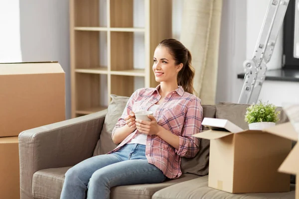 Vrouw verhuizen naar nieuw huis en het drinken van koffie — Stockfoto