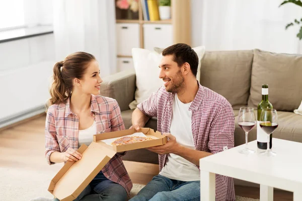 Coppia con vino mangiare pizza da asporto a casa — Foto Stock