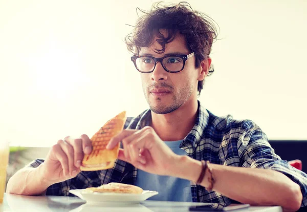 Щасливий чоловік їсть сендвіч у кафе на обід — стокове фото
