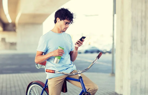 Hombre con smartphone y auriculares en bicicleta —  Fotos de Stock