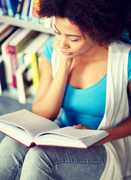 Africano studente ragazza lettura libro a biblioteca — Foto Stock