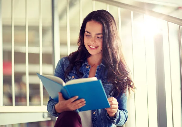 Estudante do ensino médio menina leitura livro na biblioteca — Fotografia de Stock