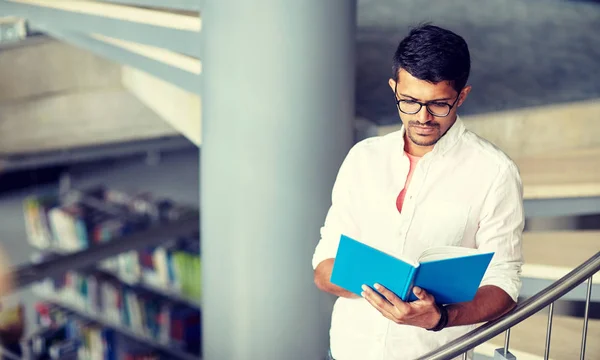 Hinduskie student mężczyzna lub chłopiec czytanie książki w bibliotece — Zdjęcie stockowe