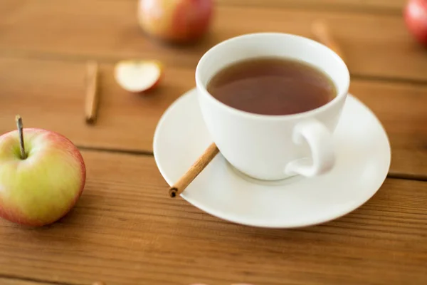 Taza de té con manzanas y canela en la mesa —  Fotos de Stock