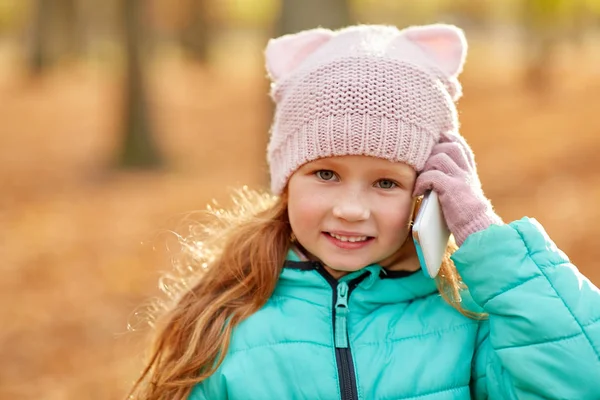 Felice ragazza chiamando su smartphone al parco autunnale — Foto Stock