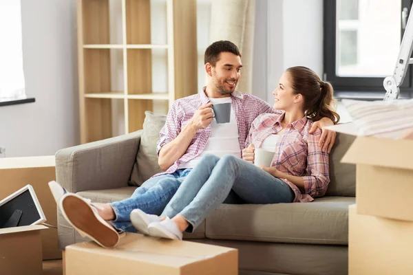 Feliz pareja bebiendo café mudándose a nuevo hogar — Foto de Stock