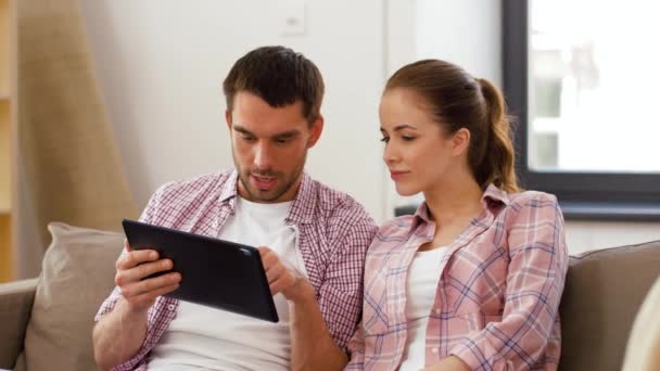Счастливая пара с планшетным компьютером в новом доме — стоковое видео