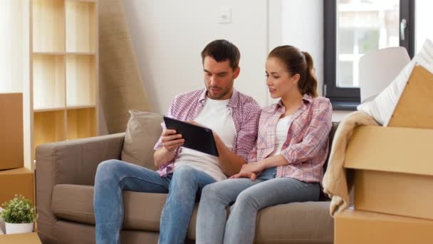Счастливая пара с планшетным компьютером в новом доме — стоковое видео
