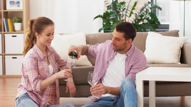 Feliz pareja bebiendo vino tinto en casa — Vídeo de stock