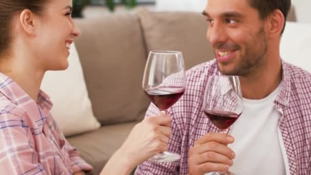 Feliz pareja bebiendo vino tinto en casa — Vídeo de stock