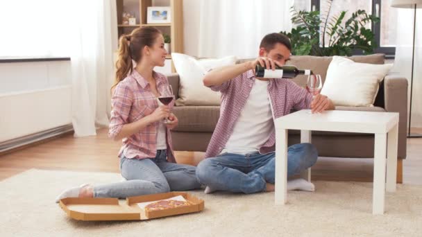 Paar met wijn en afhaalmaaltijden pizza thuis — Stockvideo