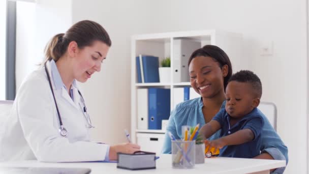 Happy mother with baby son and doctor at clinic — Stock Video