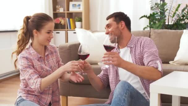 Ευτυχισμένο ζευγάρι πίνοντας κόκκινο κρασί στο σπίτι — Αρχείο Βίντεο