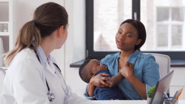 Mãe com bebê e médico com laptop na clínica — Vídeo de Stock