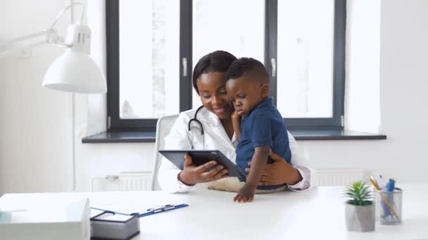 Médico mostrando tableta PC a bebé paciente en la clínica — Vídeo de stock