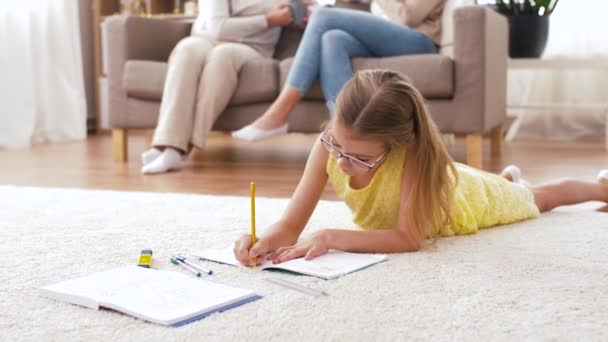 Student girl with notebook lying on floor at home — Stock Video