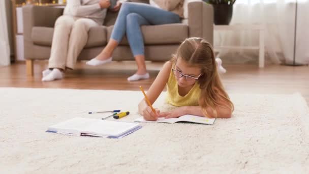 Student tjej med anteckningsbok liggande på golvet hemma — Stockvideo